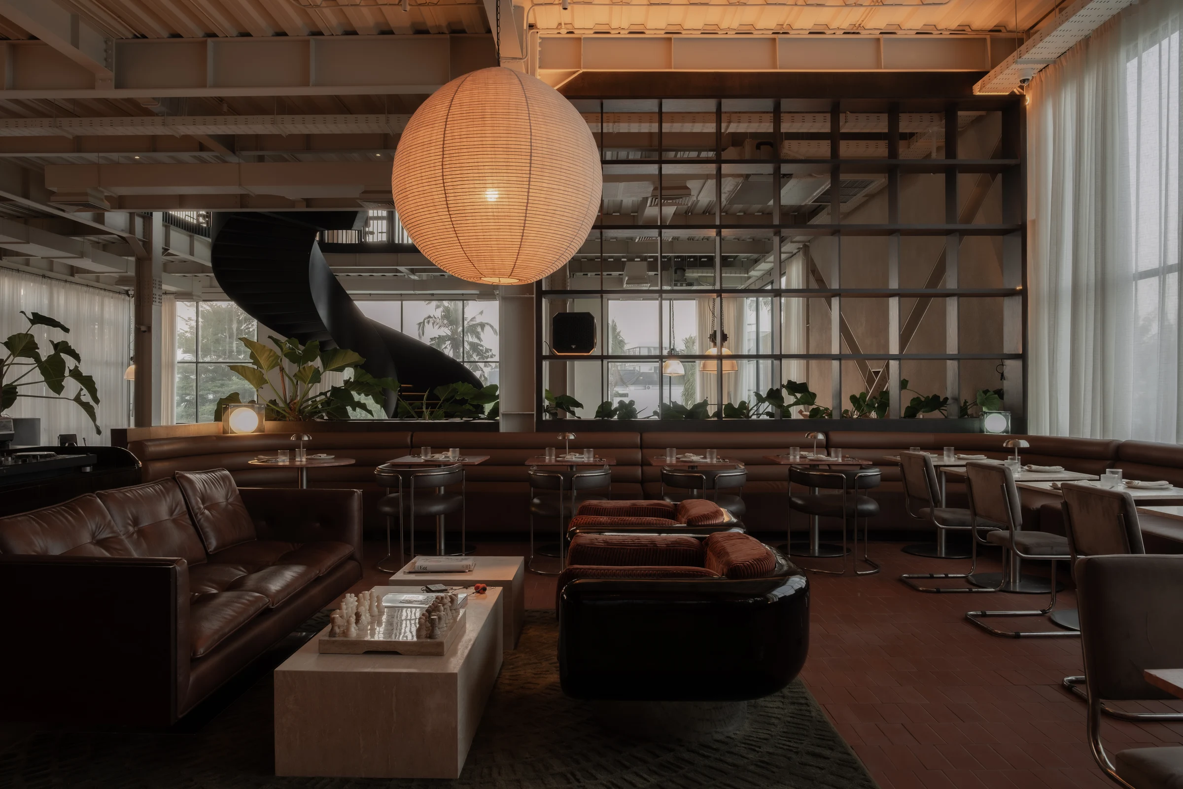 Leather seating and a glowing paper lantern in the House of Kairos lounge.